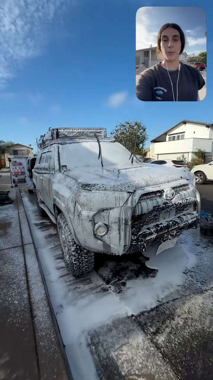 Detailer with a Toyota 4Runner covered in foam
